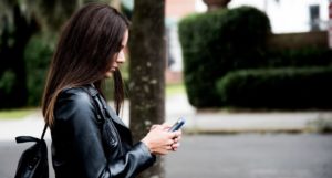 Student texting on smartphone