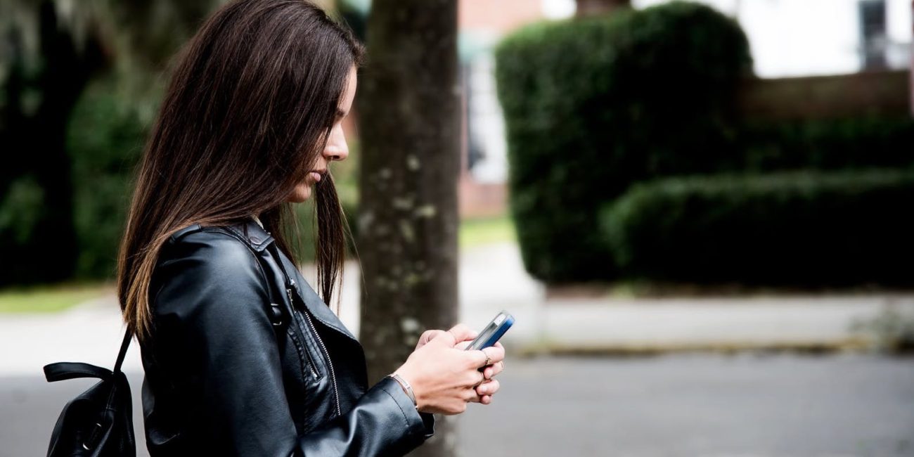 Female student texting on smartphone