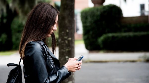 Female student texting on smartphone